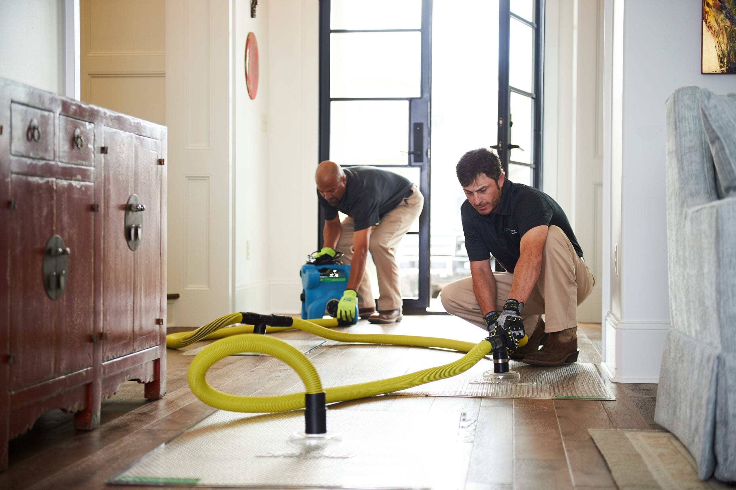 2 men with water removal equipment